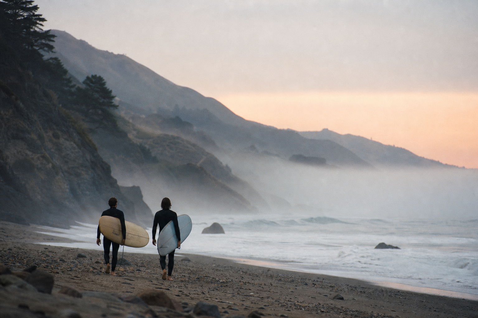 Two surfers walking a foggy Northern California beach